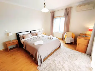 a bedroom with a large bed and a window at Sol Mar Penthouse by Da Costa in Albufeira