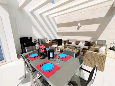 a dining table and chairs in a living room at Sol Mar Penthouse by Da Costa in Albufeira
