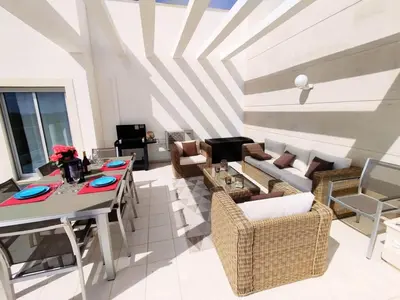 a living room with a table and a couch at Sol Mar Penthouse by Da Costa in Albufeira