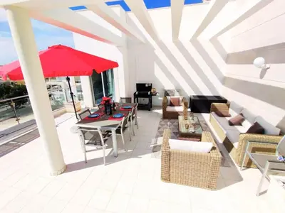 a patio with a table and chairs and an umbrella at Sol Mar Penthouse by Da Costa in Albufeira