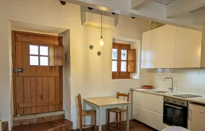 a kitchen with a table and a wooden door at Laranjeira 2 by AlmaAlgarvia in Santa Bárbara de Nexe