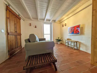 a kitchen with a couch and a chair in a room at Laranjeira 2 by AlmaAlgarvia in Santa Bárbara de Nexe