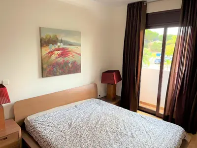 a bedroom with a bed and a wooden door at Villa Filó , Vila Sol with pool in Quarteira