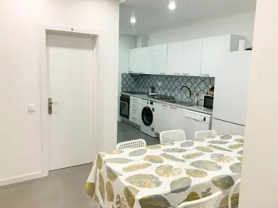 a kitchen with a table and chairs and a kitchen with a stove at Casas Sao Luis in Faro