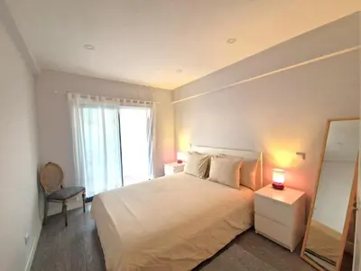 a bedroom with a bed with a mirror and a window at Quarteira flat AC balcony and view in Quarteira