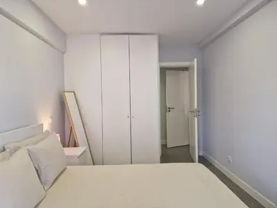a white bedroom with a bed and a closet at Quarteira flat AC balcony and view in Quarteira