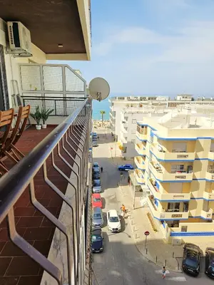a balcony with cars parked next to a building at Quarteira flat AC balcony and view in Quarteira