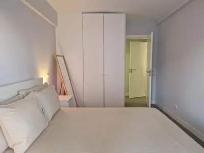 a bedroom with a white bed and a closet at Quarteira flat AC balcony and view in Quarteira