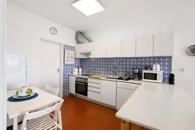 a kitchen with white cabinets and a white counter top at Apartamento Mar Azul - Quarteira in Quarteira