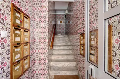 a hallway with pink wallpaper and a staircase at Apartamento Mar Azul - Quarteira in Quarteira