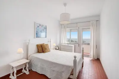 a bedroom with two beds and a blue suitcase at Apartamento Mar Azul - Quarteira in Quarteira