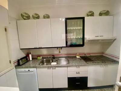 a kitchen with white cabinets and a sink at Vila Lusa Marina in Vilamoura