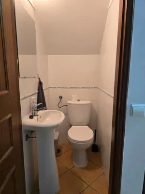 a small bathroom with a toilet and a sink at Casa Alfazema in Faro