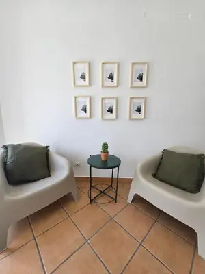 two white chairs and a table in a room at Casa Alfazema in Faro