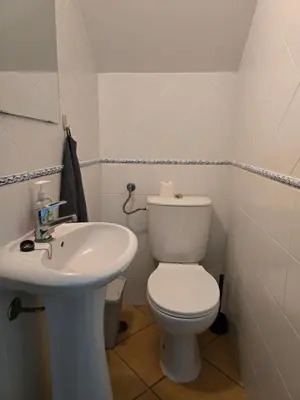 a bathroom with a white toilet and a sink at Casa Alfazema in Faro