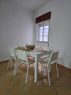a white table and chairs in a room at Casa Alfazema in Faro