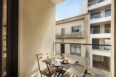 a balcony with a table with a plate of food on it at Stay Apartment in Faro