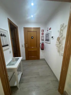 a hallway with a wooden door and a table at Modern Apartament in Al-sakia Village in Quarteira