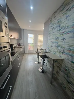 a kitchen with a table and a wall with a mural at Modern Apartament in Al-sakia Village in Quarteira