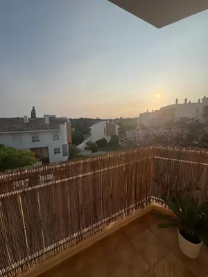 a fence on a balcony with a sunset in the background at Modern Apartament in Al-sakia Village in Quarteira