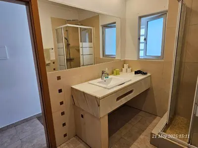 a bathroom with a sink and a mirror at Blife Cerya private rooms at Faro beach in Faro