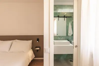 a bedroom with a bed and a bathroom with a sink at Aldeamento Aldeia do Golf V3 in Vilamoura