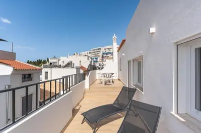 a balcony with two chairs and a table on it at Modern 1BDR with Sea View in Albufeira by LovelyStay in Albufeira