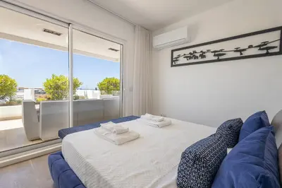 a bedroom with a blue couch and a large window at Allianca Marina - Luxury apartment by HD in Vilamoura