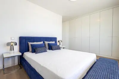 a white and blue bedroom with a large bed at Allianca Marina - Luxury apartment by HD in Vilamoura