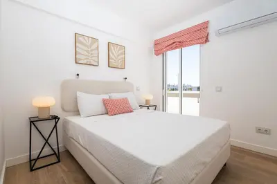 a white bedroom with a large bed and a window at Allianca Marina - Luxury apartment by HD in Vilamoura