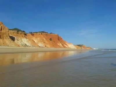 a beach with some water and some cliffs at 2 bedroom Apartment Falésia Beach in Albufeira