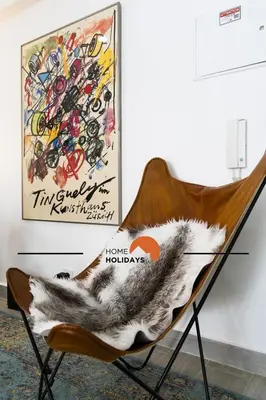 a chair with a blanket on it next to a painting at #317 Edificio Linda Vista by Home Holidays in Albufeira