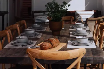 a table with a loaf of bread and cups and saucers at Terra X Apartments in Faro