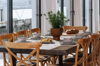 a wooden table with chairs and food on it at Terra X Apartments in Faro