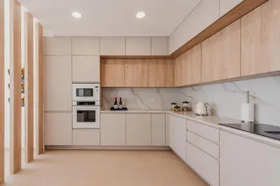 a kitchen with white appliances and wooden cabinets at Terra X Apartments in Faro
