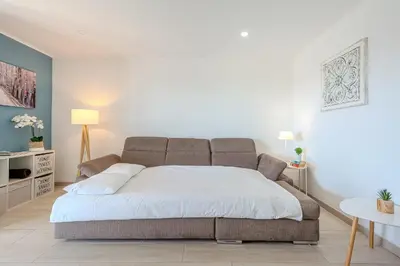 a bedroom with a large bed with white sheets at Salgados Sunset and Sea View Apartment in Guia