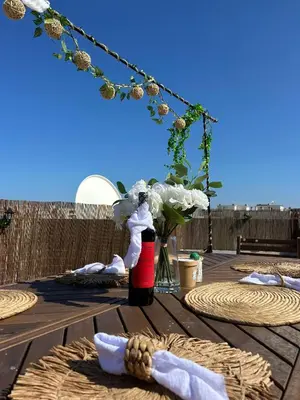 a table with a vase of flowers on a deck at Beach penthouse paradise T4 in Quarteira
