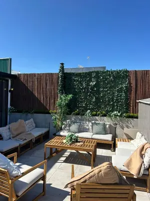 a patio with couches and tables and a hedge at Beach penthouse paradise T4 in Quarteira