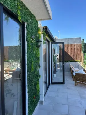 an ivy covered wall on a house with a patio at Beach penthouse paradise T4 in Quarteira