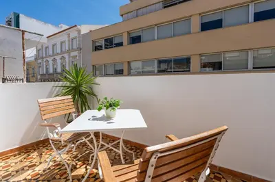 a table and chairs on a balcony with a building at Casa Bella in Faro