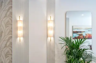 two lights on a wall with a mirror and a plant at Casa Bella in Faro