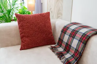 a red pillow on a couch with a plaid blanket at Casa Bella in Faro