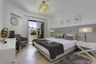 a bedroom with a bed and a desk and a chair at CLUB ALBUFEIRA - 2 bedroom apartment, air conditioning and pools in Albufeira