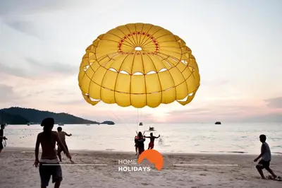 a group of people on the beach with a large yellow parachute at #321 Lageado 1S by Home Holidays in Vale de Pedras