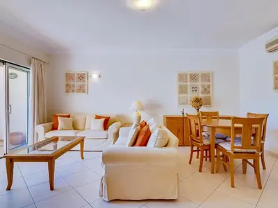 a living room with a couch and a table at 1 bdr apartment with pool next to Laguna Golf Course in Vilamoura