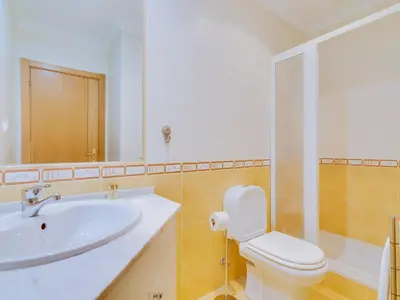 a bathroom with a sink and a toilet and a mirror at 1 bdr apartment with pool next to Laguna Golf Course in Vilamoura