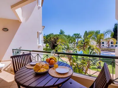 a table with a bowl of fruit on a balcony at 1 bdr apartment with pool next to Laguna Golf Course in Vilamoura