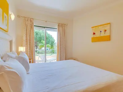 a bedroom with a large white bed and a window at 1 bdr apartment with pool next to Laguna Golf Course in Vilamoura