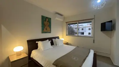 a bedroom with a bed with white sheets and a window at Figo by Check-in Portugal in Quarteira