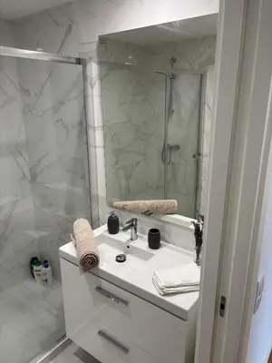 a white bathroom with a sink and a mirror at Casa Verde in Albufeira